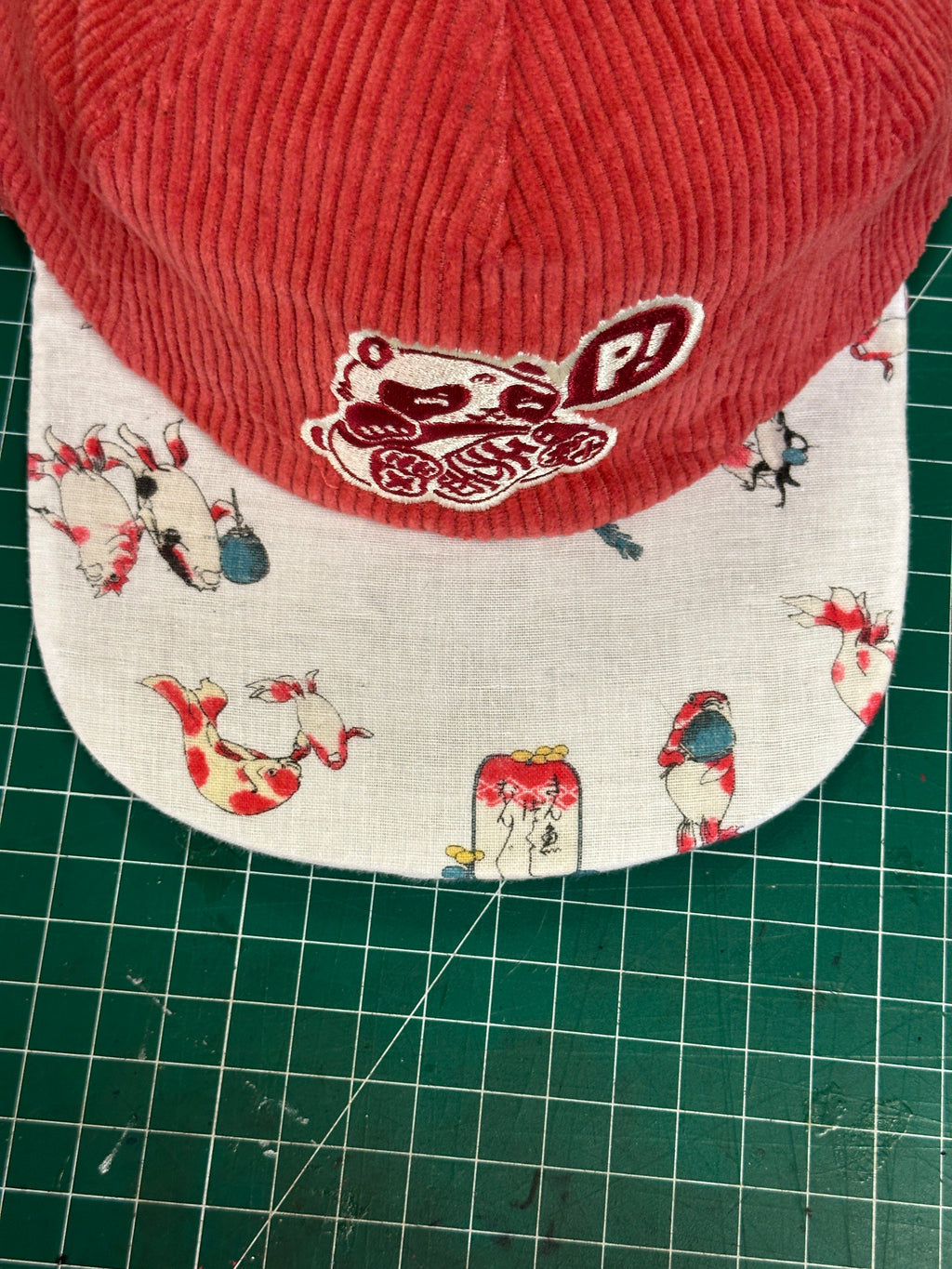 Salmon corduroy branded basics with Koi brim 1 of 1