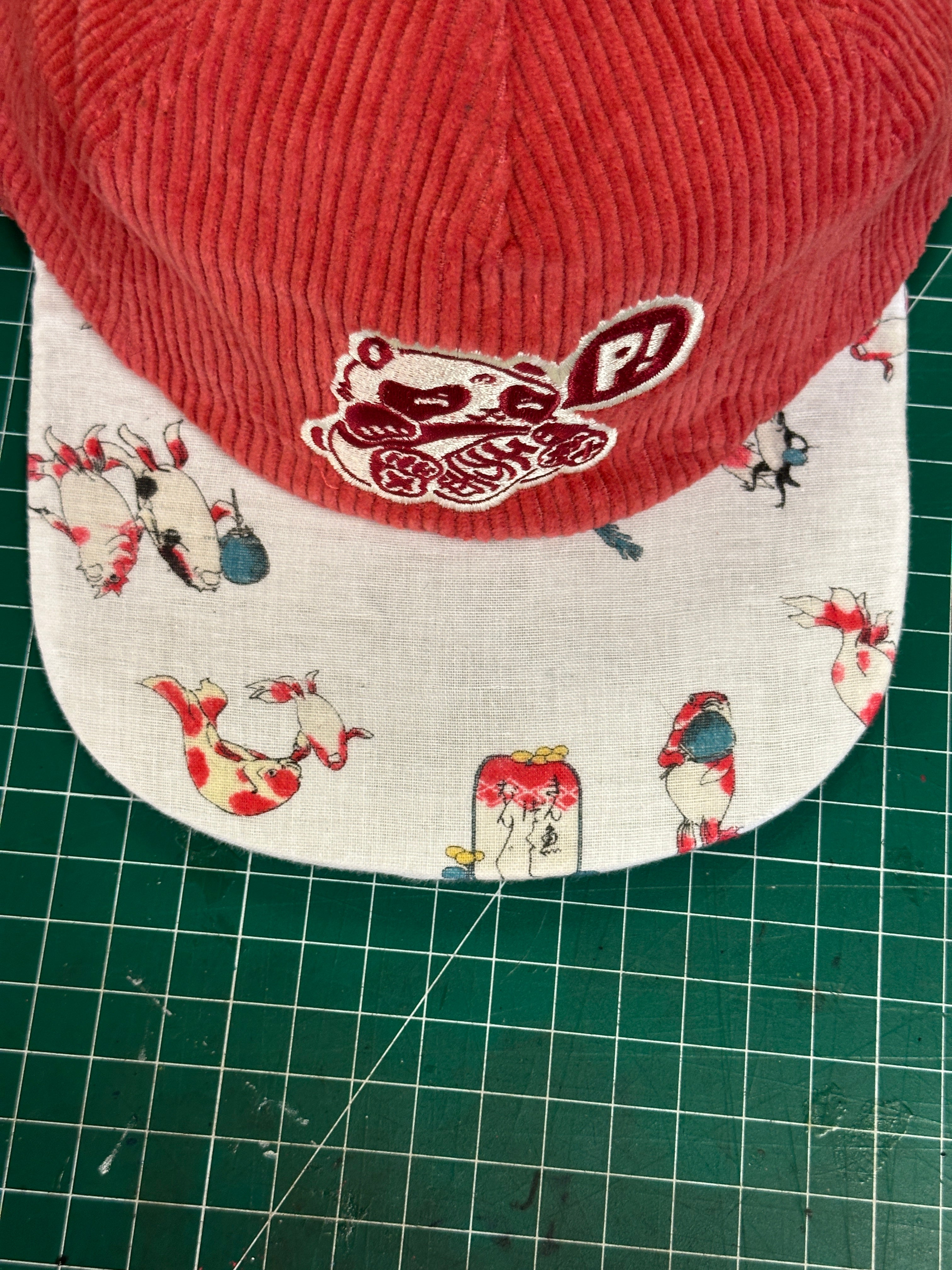 Salmon corduroy branded basics with Koi brim 1 of 1